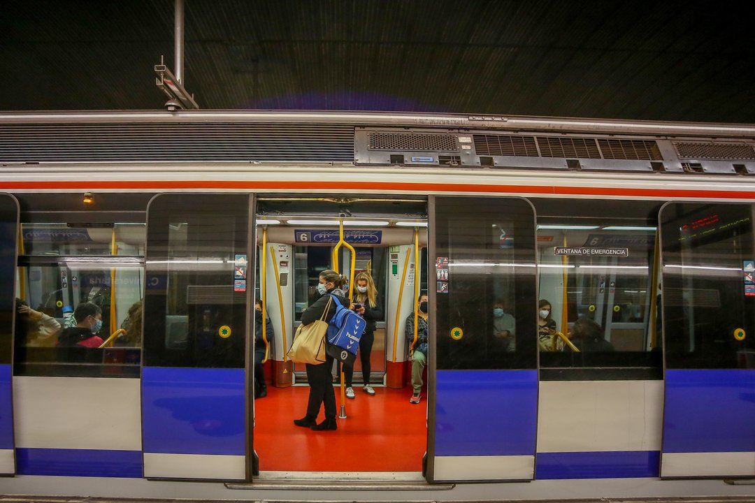 Varios personas viajan en el interior de un vagón en la Estación de Metro de Ciudad Universitaria durante el primer día laborable con restricciones de movilidad en toda la capital de Madrid (España), a 5 de octubre de 2020.