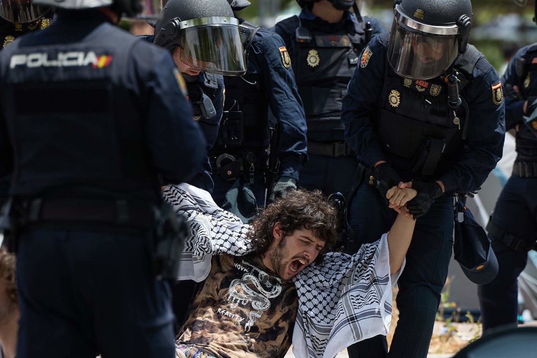 Policías apartan a un manifestante propalestino de la acampada en la Universidad Complutense de Madrid (Foto: Jesús Hellín / Europa Press).