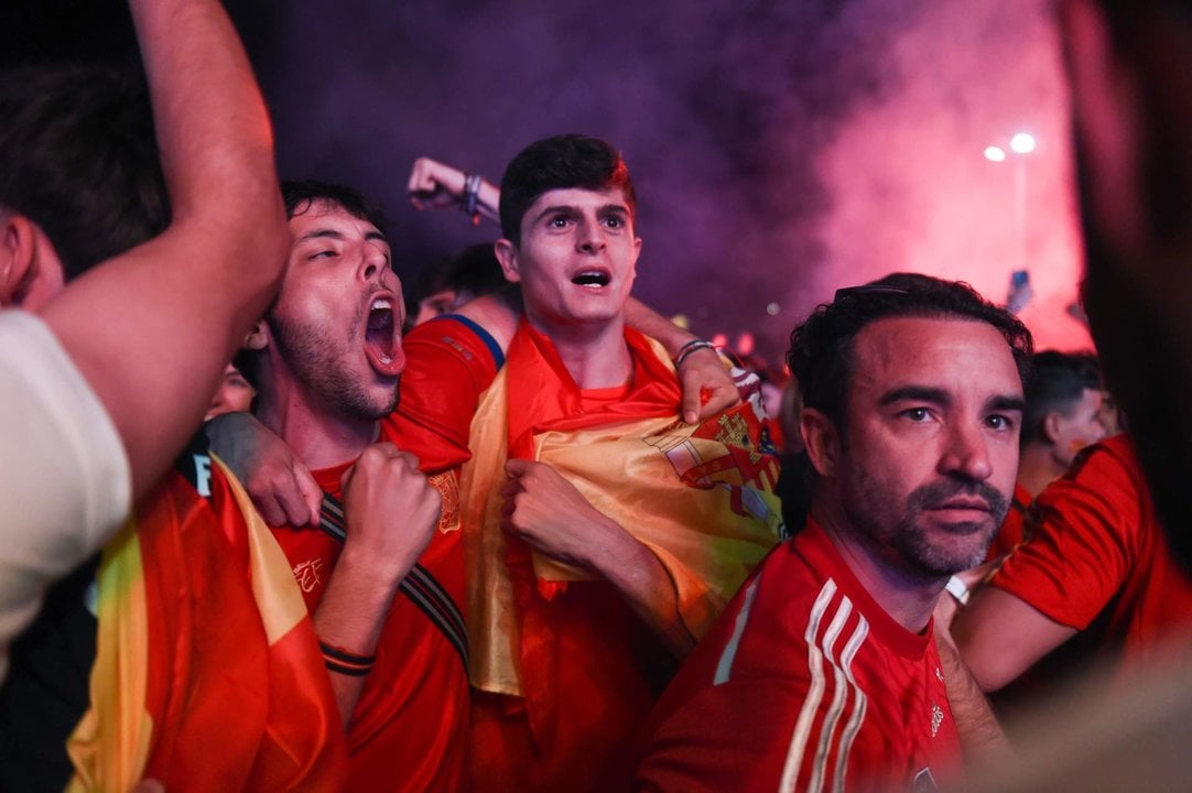 Decenas de personas celebran la victoria en el partido de semifinales de la Eurocopa entre España y Francia visto desde una pantalla gigante en la explanada de Puente del Rey.
